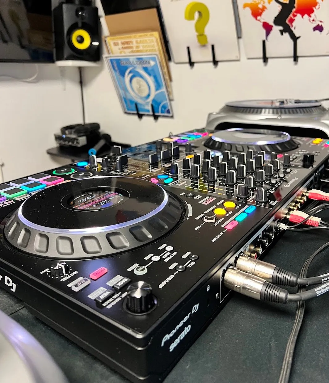 The Pioneer DJ DDJ-FLX10 controller on the desk, with the turntable behind it and vinyl on the wall